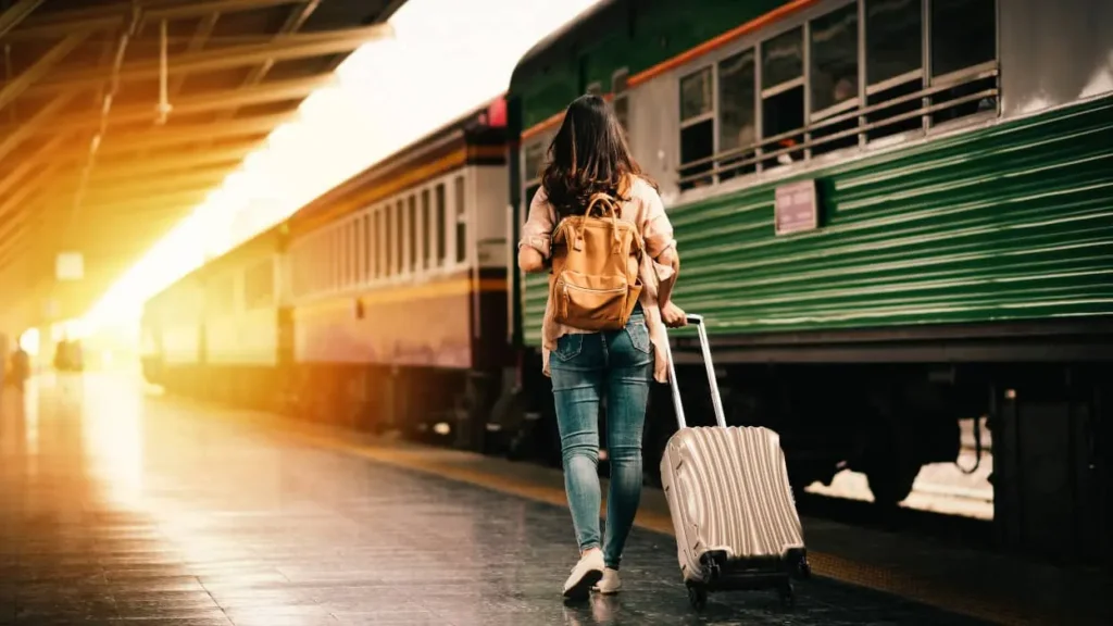 kobieta z walizką na peronie na stacji kolejowej