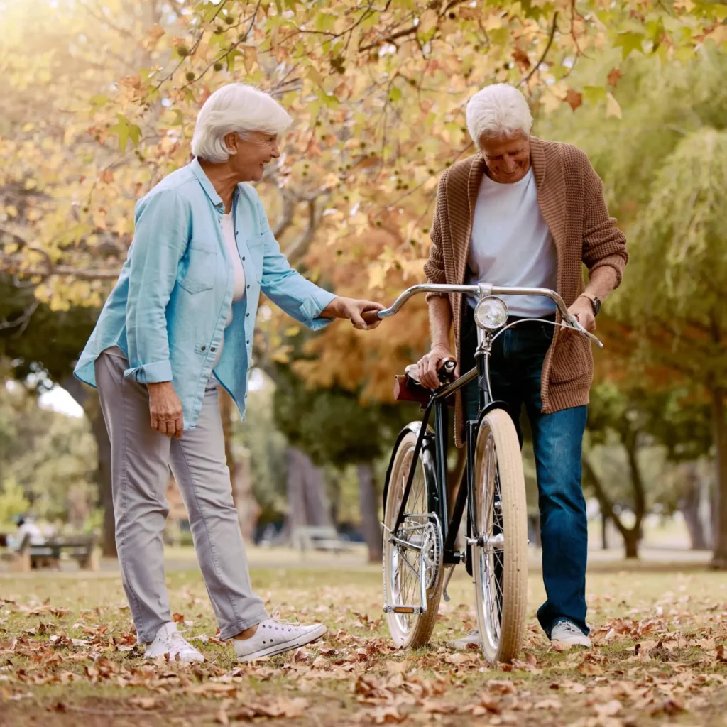 seniorzy z rowerem w parku - aktywny senior