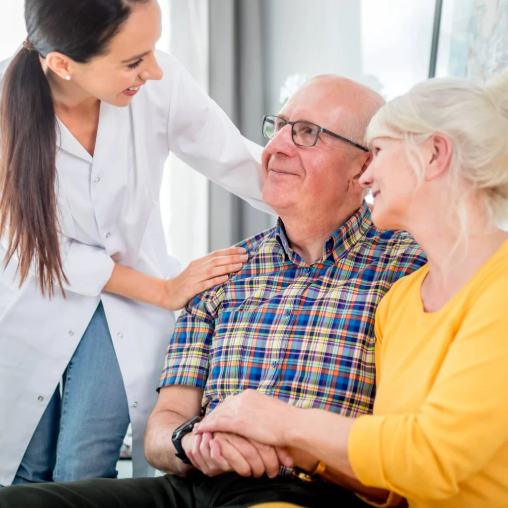 opiekunka seniorów stoi przy seniorach - wszyscy są uśmiechnięci