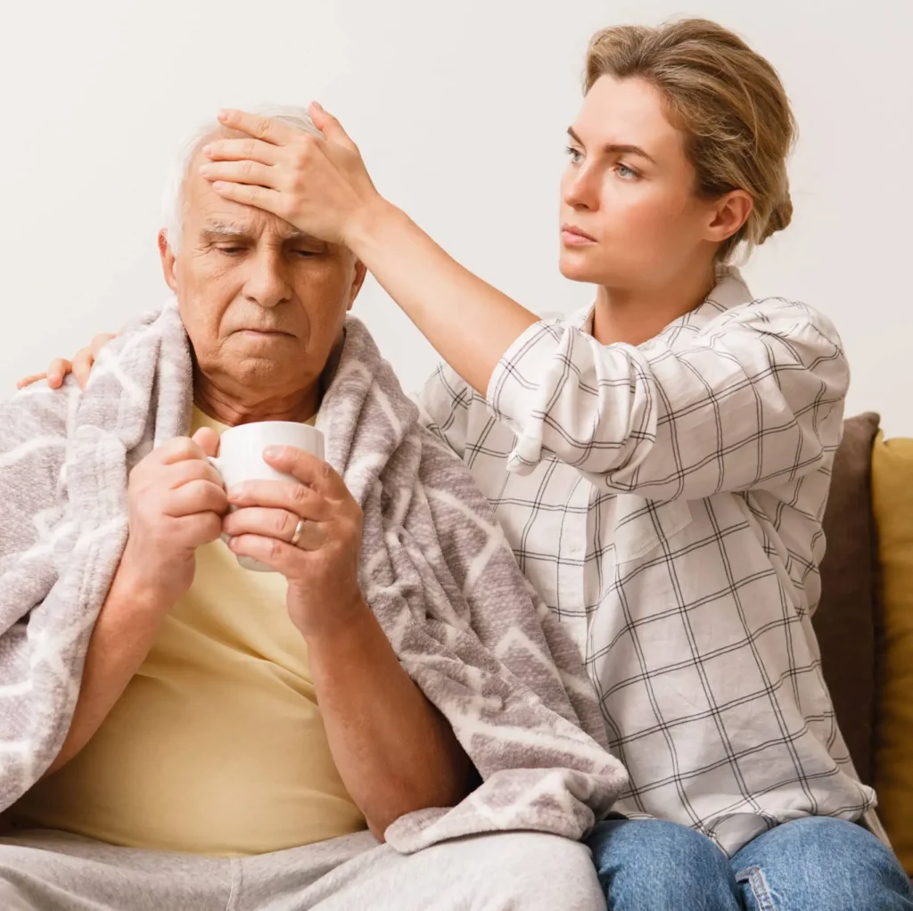 grypa - senior w koci trzyma kubek z herbatą