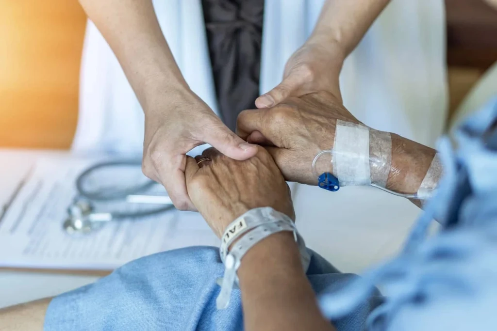 opieka paliatywna w domu - ręce opiekunki i seniora/seniorki