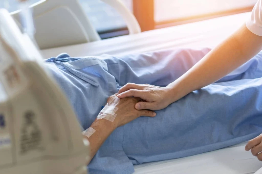 opieka paliatywna w domu - ręce opiekunki i seniora/seniorki